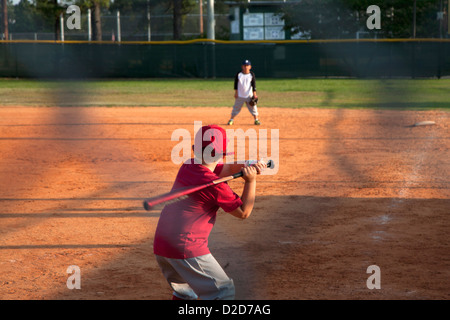 Rear view of a boy preparing to swing a bat on baseball diamond Stock Photo