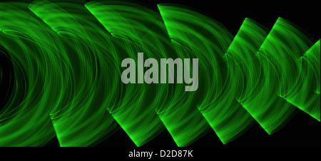Green light trails creating an abstract wave pattern on a black background Stock Photo