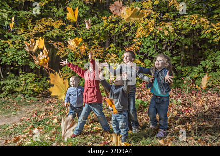 Five kids trying to catching falling autumn leaves Stock Photo
