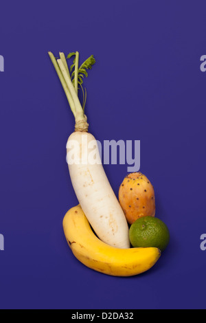 A turnip, banana, lime and prickly pear arranged into an abstract shape Stock Photo