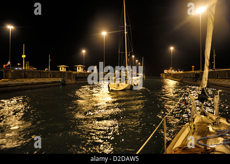 Two sailing yachts leaving Gatun Lock after a night time transit up from the Atlantic to Gatun Lake. Panama Canal Stock Photo