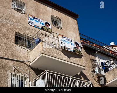 Signs bearing the photo of Rabbi Ovadia Yosef, spiritual leader of the Shas Party, hang from an apartment building balcony in Je Stock Photo