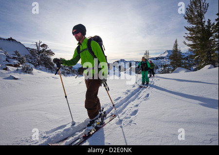 Skiers and snowboarders skin through powder snow on Carson Pass in the Sierra Nevada mountains near Lake Tahoe, CA. Stock Photo