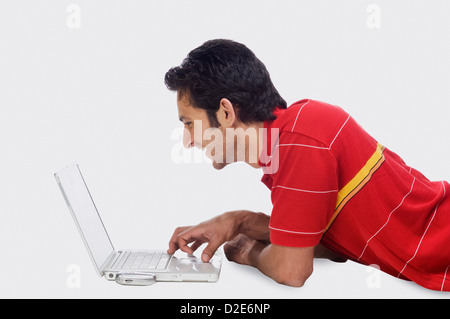 Close-up of a man using a laptop and smiling Stock Photo