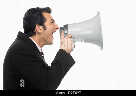 Businessman shouting into a megaphone Stock Photo