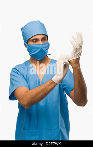 Surgeon putting on surgical gloves Stock Photo