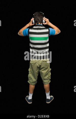 Rear view of a man listening to headphones Stock Photo