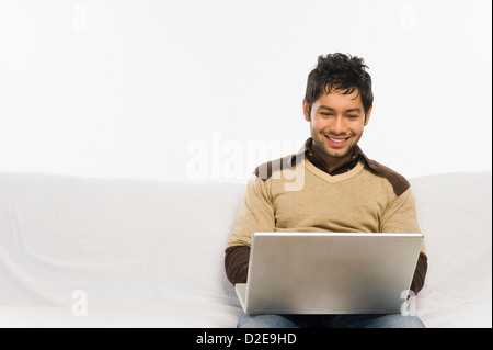 Man working on a laptop and smiling Stock Photo