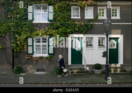 Essen, Germany, older woman in front of the row houses in the garden city Margarethenhoehe Stock Photo