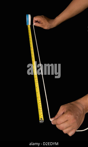 Close-up of a man measuring string with a tape measure Stock Photo - Alamy