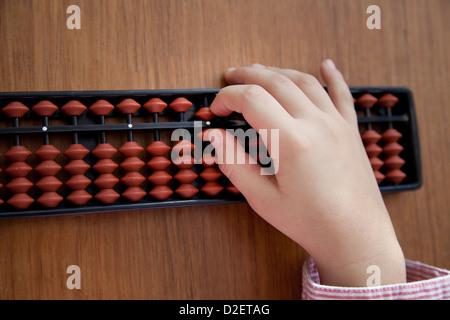 Child's hand using a Japanese abacus (soroban)  also known as counting frame. Stock Photo
