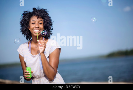 A young woman blows bubbles at Lake Wedowee, Alabama Stock Photo