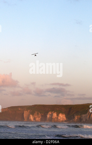 Autogyro / Gyroplane flying over cliffs Whiterocks beach North Antrim Coast Stock Photo