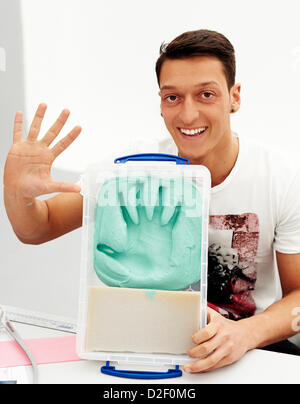 (HANDOUT - FILE) An archive handout dated 16 January 2013 shows Real Madrid's Mesmut Ozil holds his hand up after making a cast of it by Madame Tussauds wax museum employees in Madrid, Spain. The 24 year-old is the first active German soccer player to have his wax figure made and the third German soccer player after Oliver Kahn and Franz Beckenbauer. Photo: MADAME TUSSAUDS (ATTENTION: For editorial use only.) Stock Photo