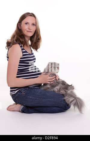 Pregnant woman with persian cat, studio shot on white background Stock Photo