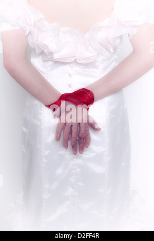 a woman in a white dress with tied hands Stock Photo