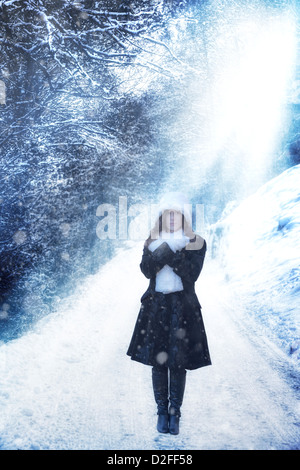 a woman in a black coat is standing on a winter street Stock Photo