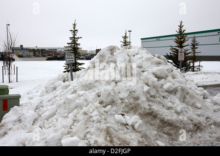 large pile of snow for collection cleared from residential streets Saskatoon Saskatchewan Canada Stock Photo