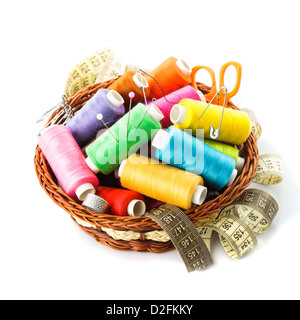 Sewing items in basket: threads, pins, meter and scissors on white Stock Photo