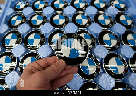 A hand is holding a BMW emblem on Wednesday, 7 March 2012, at the BMW factory in Regensburg. Due to a sales record in 2011, the profit of the Bavarian automobile producer also rised in unknown hights. Stock Photo
