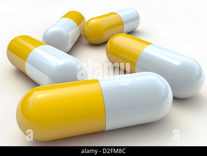 Close up of yellow and white plastic pill capsules on white background Stock Photo