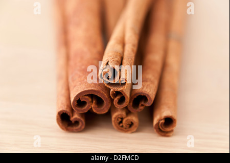 Cinnamon sticks on a wooden chopping board Stock Photo