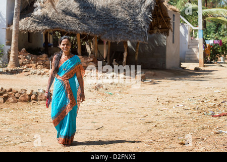 Indian woman wearing a blue sari walking in a rural indian village. Andhra Pradesh, India Stock Photo