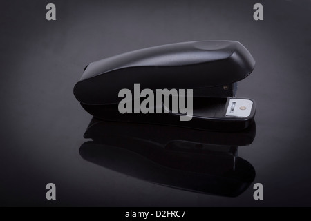 photo of a stapler on a black shiny background Stock Photo