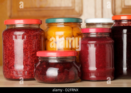 Sweet preserves as jams and compotes on table in kitchen Stock Photo