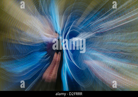 Motion blur spinning light trails and a zoomed pattern with impression of a suited gentleman Stock Photo