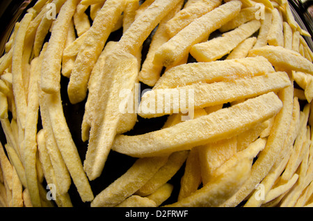 extreme view of a pile of frozen oven chips ready to be cooked on an oven tray Stock Photo