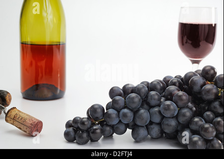 Black grapes, red wine bottle, cork and glass, studio shot Stock Photo