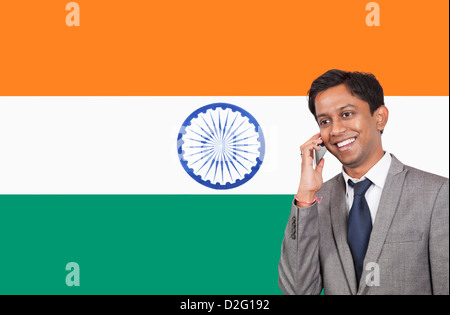 Young businessman using cell phone over Indian flag Stock Photo