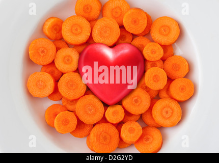 Red heart on a white dish of fresh carrots, healthy food, healthy eating concept Stock Photo