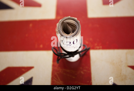 Twenty pounds sterling banknote roll on an image of a Union Jack Flag Stock Photo