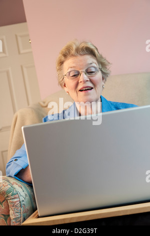 Mature woman using a laptop and smiling Stock Photo