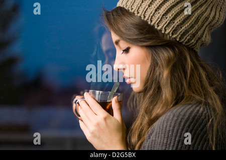 Portrait of a dreamy young brunette with hot tea. Stock Photo