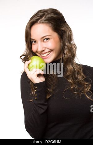 Gorgeous young brunette woman showing off fresh green apple. Stock Photo