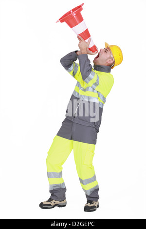 A road worker using a cone as a loudhailer. Stock Photo