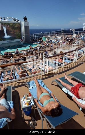 Passengers sunbathing at sea on the aft deck of the cruise ship Norwegian Epic. Stock Photo