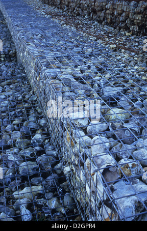Detail of sea defence wall of gabions or wire nets containing large grey pebbles Stock Photo