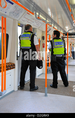 Police patrol in train carriage on London Overground service Stock Photo