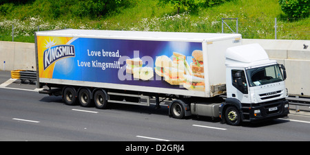 Advertising on side of articulated trailer for Kingsmill bread a brand owned by Associated British Foods behind an Iveco lorry driving on UK motorway Stock Photo