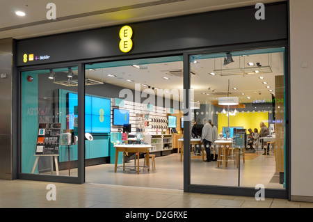 EE joint business venture Orange & T Mobile phone companies  with open plan entrance from shop front customers  inside indoor shopping mall Essex UK Stock Photo