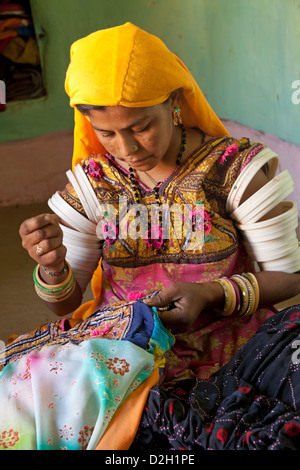 India, Rajasthan, Thar Desert, woman in traditional Rajasthani costume sewing Stock Photo