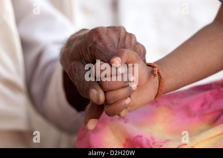 India, Rajasthan, Jodhpur, very old man's hand being held young girl's hand Stock Photo