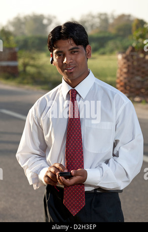 India, uttar Pradesh, Agra Indian businessman using smartphone and bluetooth headset Stock Photo