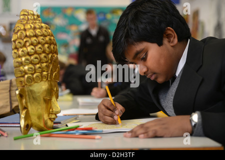 An eleven year old boy drawing a mask in an art lesson at Pates Grammar School in Cheltenham, Gloucestershire UK