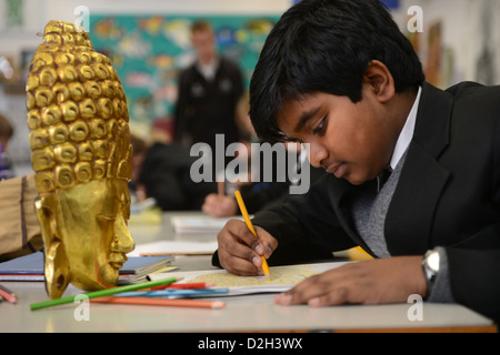 An eleven year old boy drawing a mask in an art lesson at Pates Grammar School in Cheltenham, Gloucestershire UK