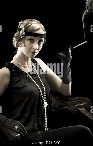 Twenties lady smoking a cigarette with a cigarette holder Stock Photo